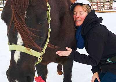 woman hugging horse in snow